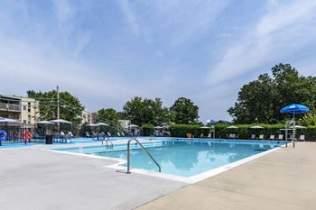 A swimming pool with umbrellas and buildings in the background